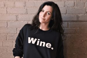 Renée in a black sweater that says wine