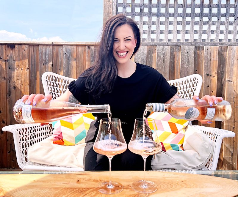 Renée pouring two bottles of Rosé in two glasses